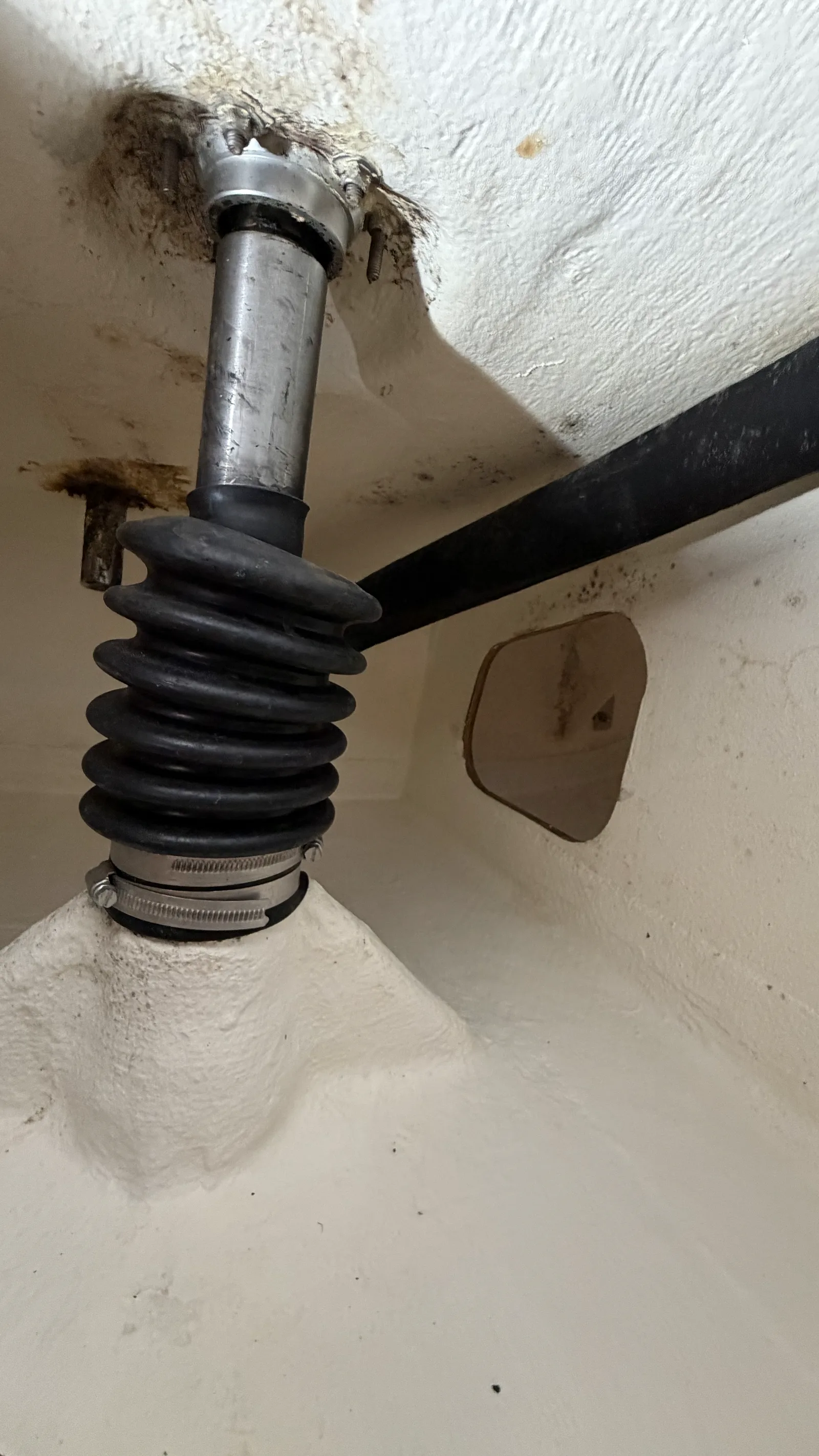 État initial avant refit : ancien soufflet caoutchouc et axe du safran dans le coffre arrière du J/92s, jeu et corrosion visibles autour du tube de jaumière