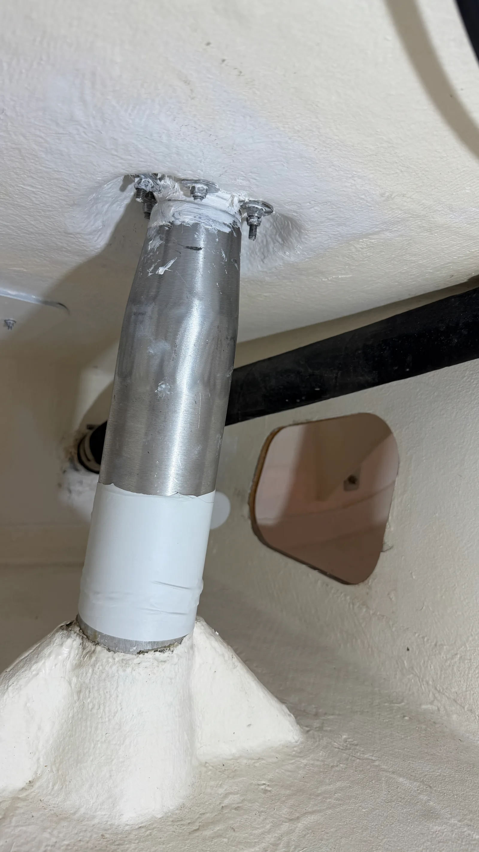Mèche de safran d'un J/92s remontée après remplacement des bagues : axe alu propre, joint d'étanchéité au pont refait en époxy blanc, manchon protecteur autour du tube — le résultat visible du travail
