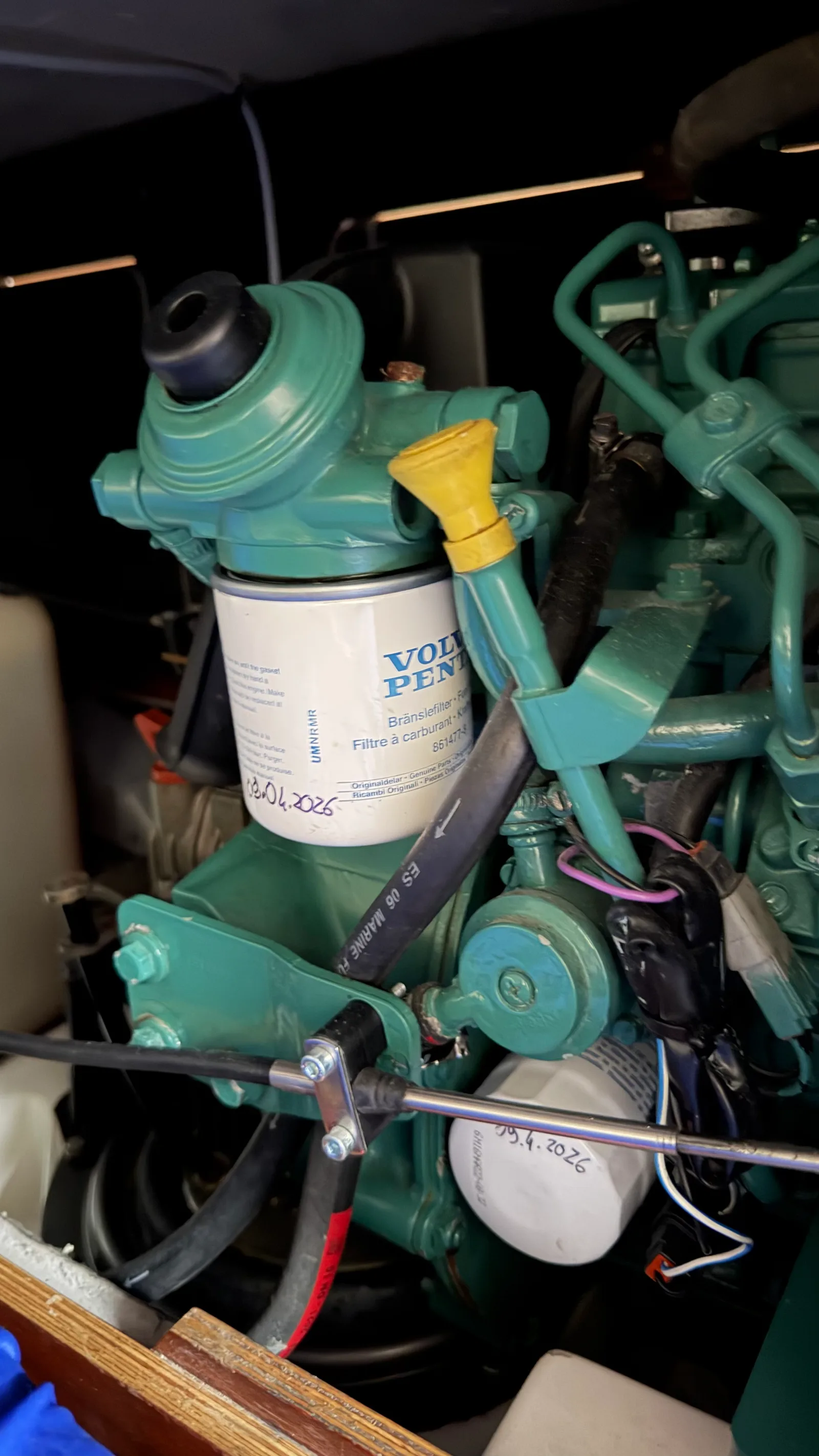 Moteur Volvo Penta D1-13 après l'entretien annuel : vue d'ensemble du bloc avec filtre à gasoil neuf en haut et filtre à huile neuf en bas, tous deux datés à la main de la date de montage
