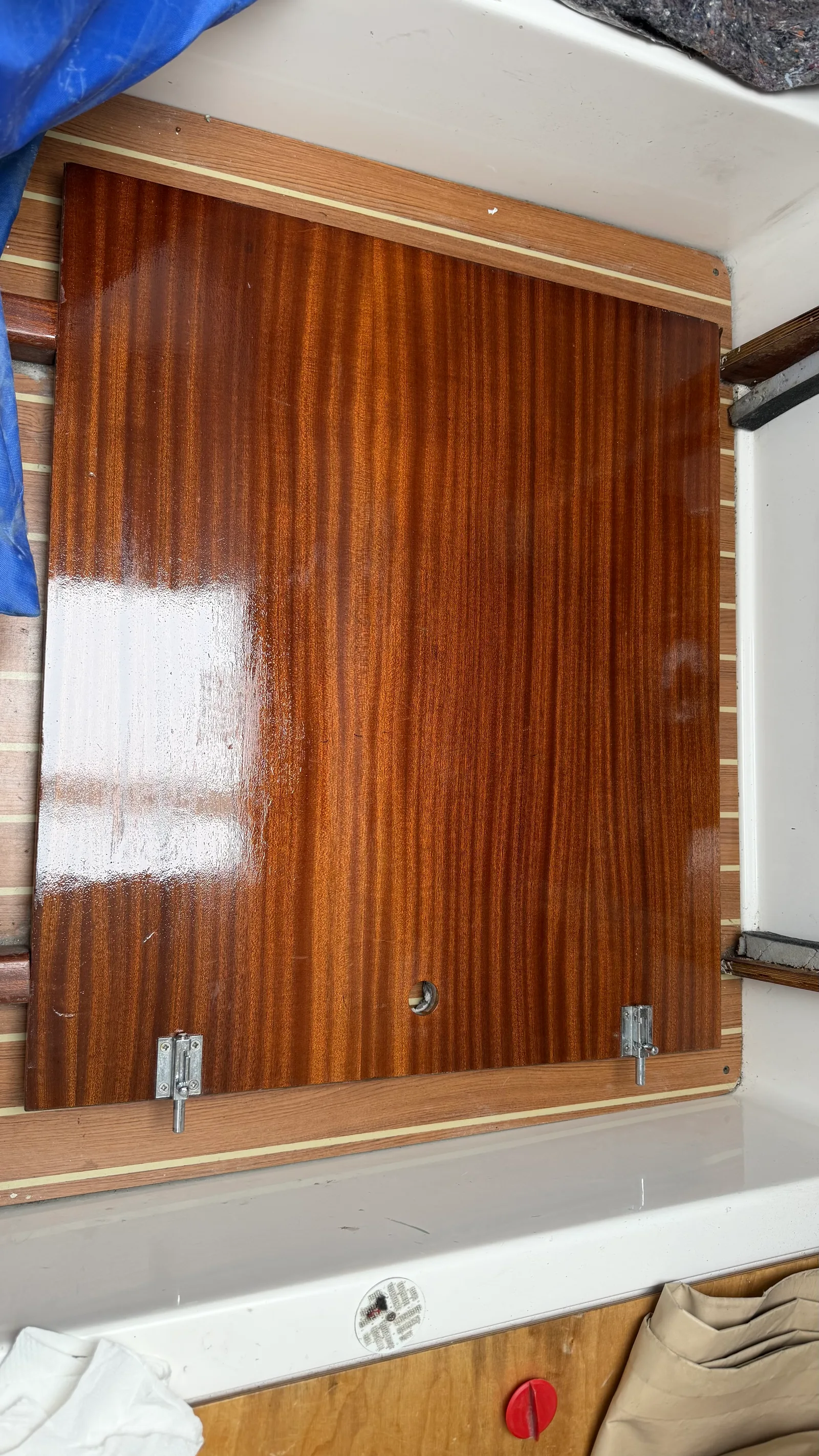 Panneau bois du compartiment moteur avec vernis Wood Line frais, film brillant et humide révélant le veinage de l'acajou