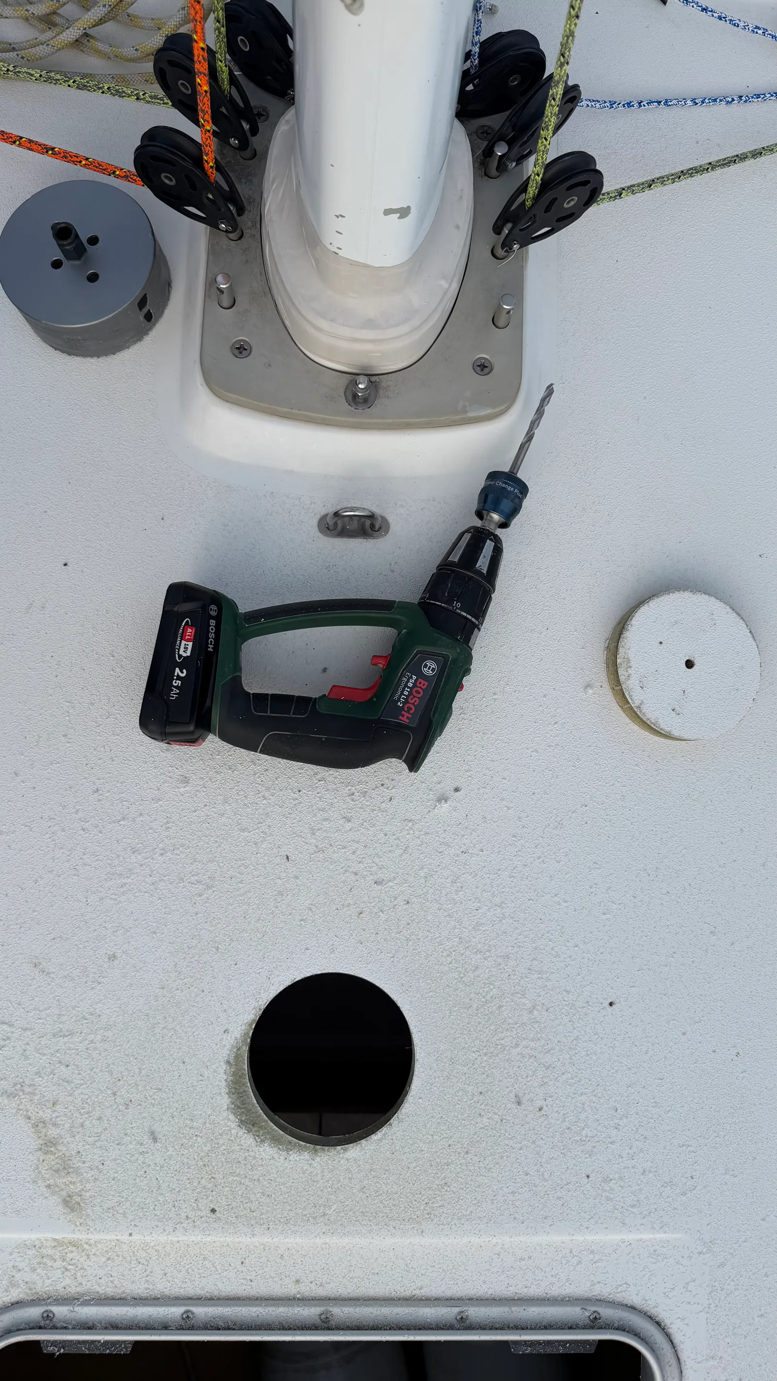 Découpe de la grande ouverture du Solarvent dans le pont du J/92s : trou circulaire au trépan, disque de découpe posé à droite, avant scellement et pose de l'aérateur