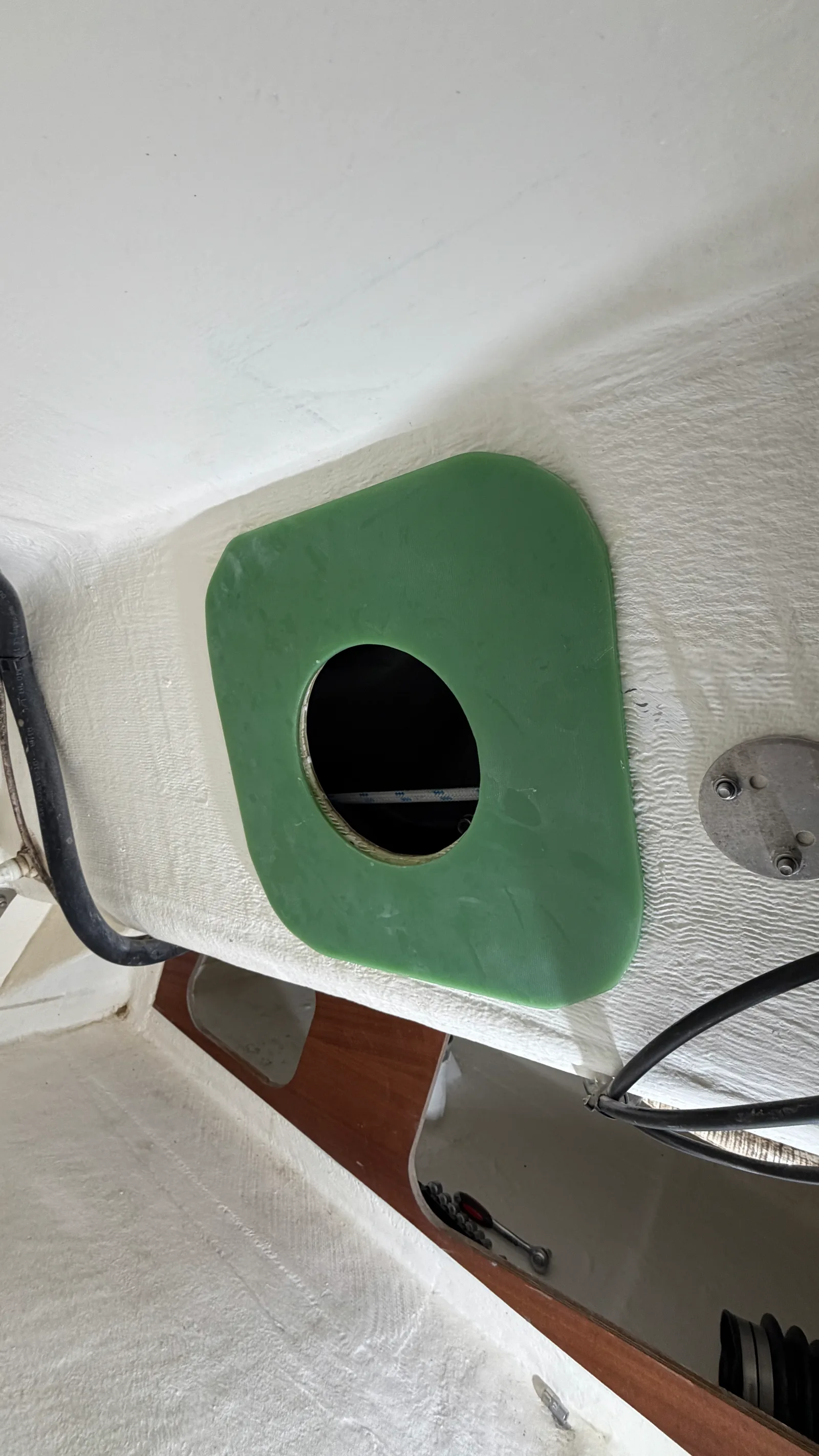 Renfort FP4 vert de 5 mm collé à l'époxy sur la paratie arrière du cockpit, avec la découpe circulaire pour le passage de la pompe manuelle Whale — la base rigide qui absorbe les efforts de la leve